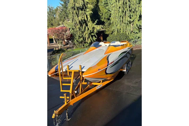 Slide: The Image of 2007 Eliminator Daytona 30 powerboat with vibrant orange and white design on a trailer. - 55