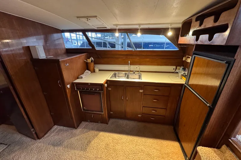 Slide: The Image of Vintage 1967 Pacemaker 37 yacht kitchen with wood cabinetry and dual sink. - 12