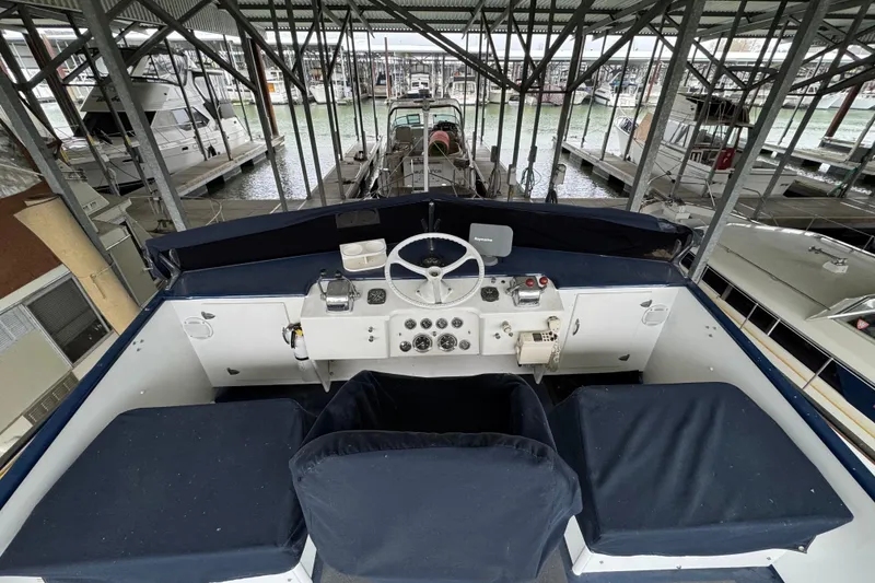 Slide: The Image of 1967 Pacemaker 37 boat helm with covered seats in a marina setting. - 16