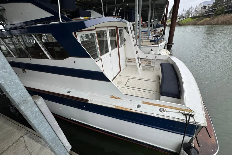 Slide: The Image of 1967 Pacemaker 37 boat docked, featuring blue and white exterior with spacious deck area. - 4