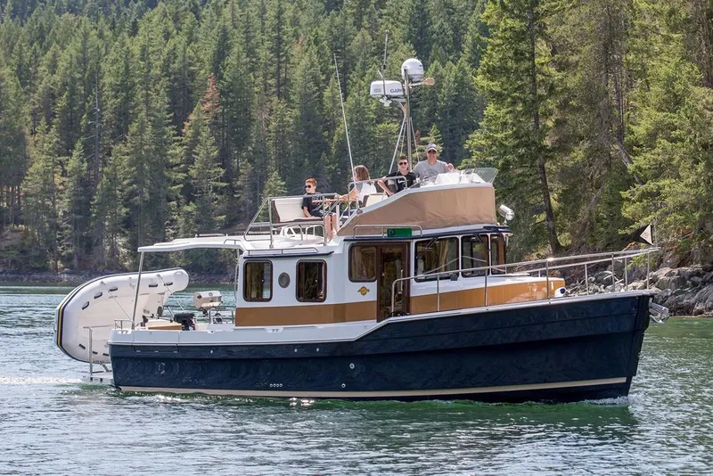 The Image of Manufacturer Provided Image: 2025 Ranger Tugs R-31 CB cruising on a scenic forested lake. - 0
