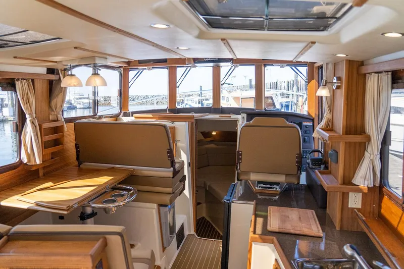 Slide: The Image of Manufacturer Provided Image: Interior of 2025 Ranger Tugs R-31 CB, featuring elegant wood finishes and spacious seating. - 16