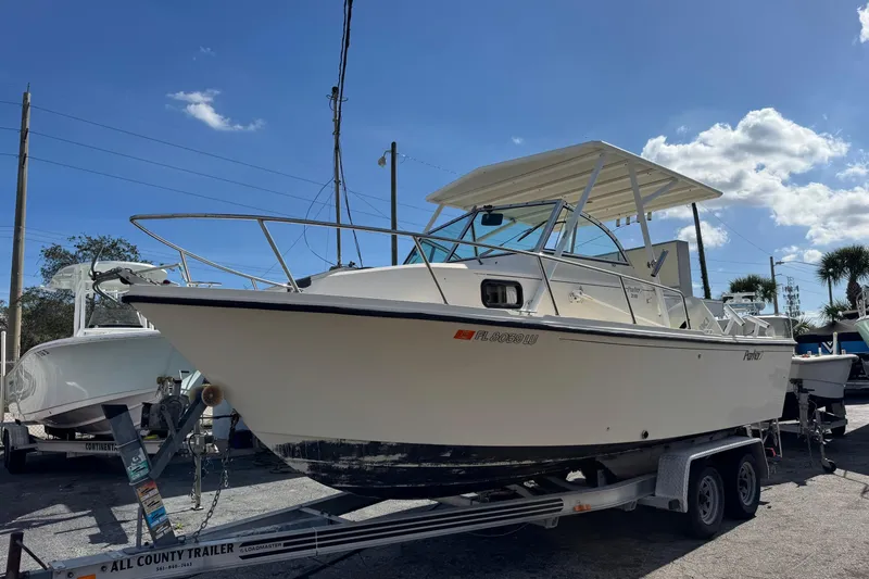 Slide: The Image of 2001 Parker 2110 Walkaround boat on trailer under clear blue sky. - 0