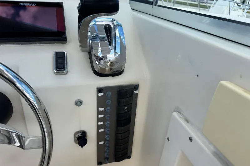Slide: The Image of Control panel of a 2001 Parker 2110 Walkaround boat with steering wheel and throttle. - 14