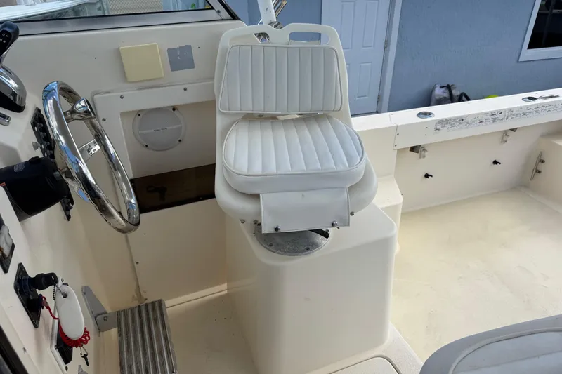 Slide: The Image of 2001 Parker 2110 Walkaround boat interior with steering wheel and white captain's chair. - 15