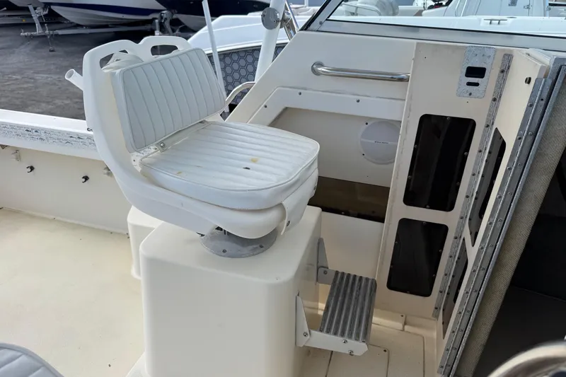 Slide: The Image of 2001 Parker 2110 Walkaround boat interior with white captain's chair and control panel. - 16