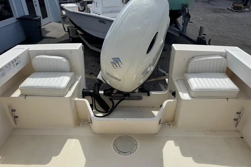 Slide: The Image of 2001 Parker 2110 Walkaround boat interior with Suzuki outboard motor and cushioned seating. - 22