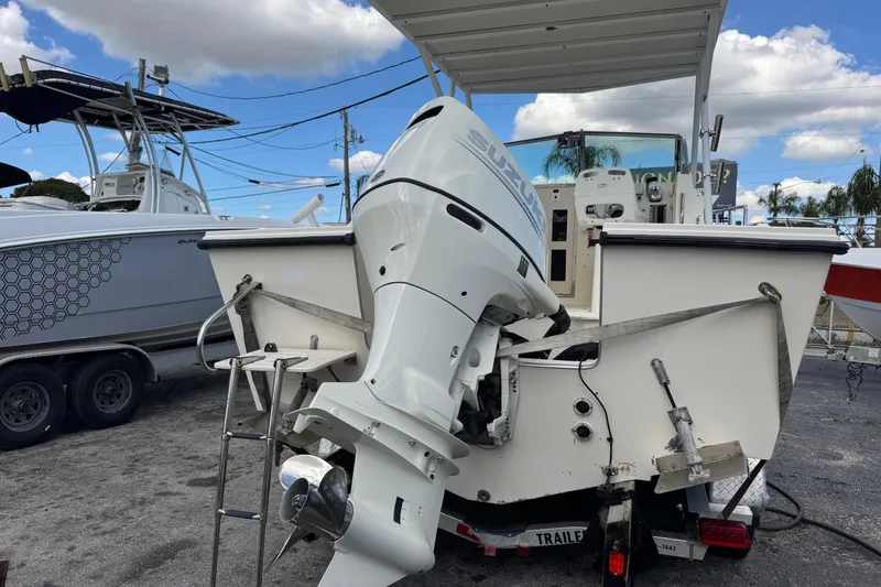 Slide: The Image of 2001 Parker 2110 Walkaround boat with Suzuki outboard motor, parked on a trailer. - 29