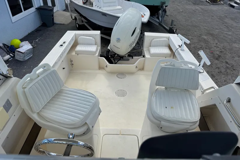 Slide: The Image of 2001 Parker 2110 Walkaround boat interior with white seating and outboard motor. - 6