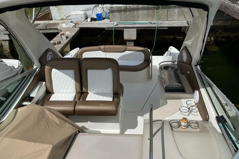 Slide: The Image of 2008 Sea Ray 310 Sundancer interior with seating and amenities, docked at a marina. - 10
