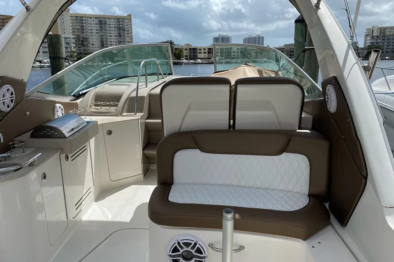 Slide: The Image of 2008 Sea Ray 310 Sundancer boat interior with seating and kitchenette, docked in a marina. - 11