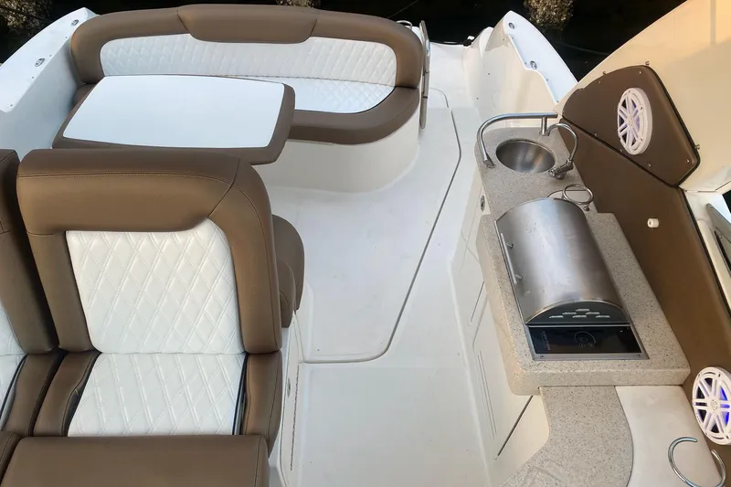 Slide: The Image of 2008 Sea Ray 310 Sundancer interior with seating, table, and kitchenette area. - 18