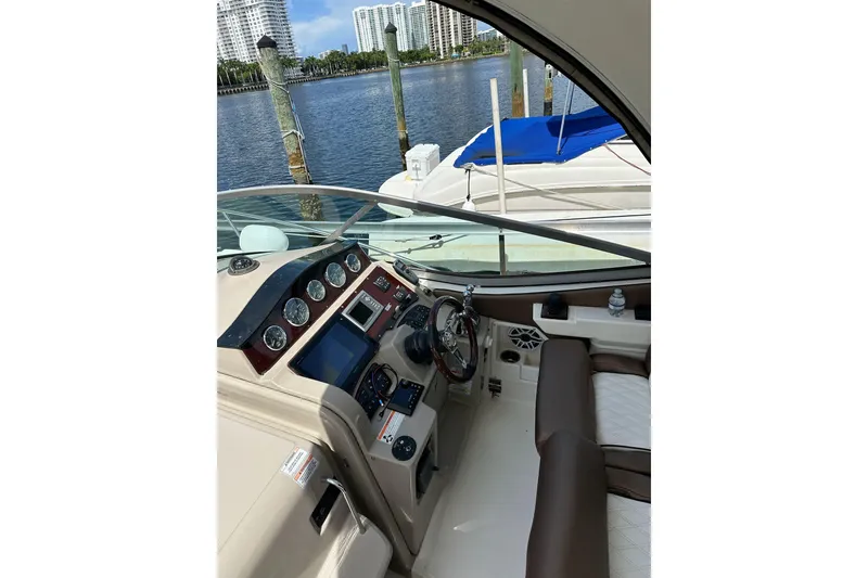 Slide: The Image of 2008 Sea Ray 310 Sundancer helm with modern controls, docked by waterfront. - 21