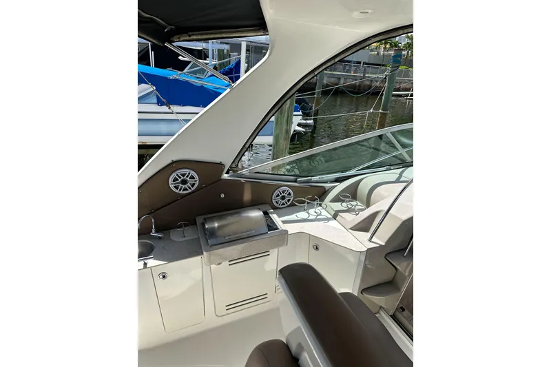Slide: The Image of 2008 Sea Ray 310 Sundancer cockpit with seating, speakers, and water view. - 25