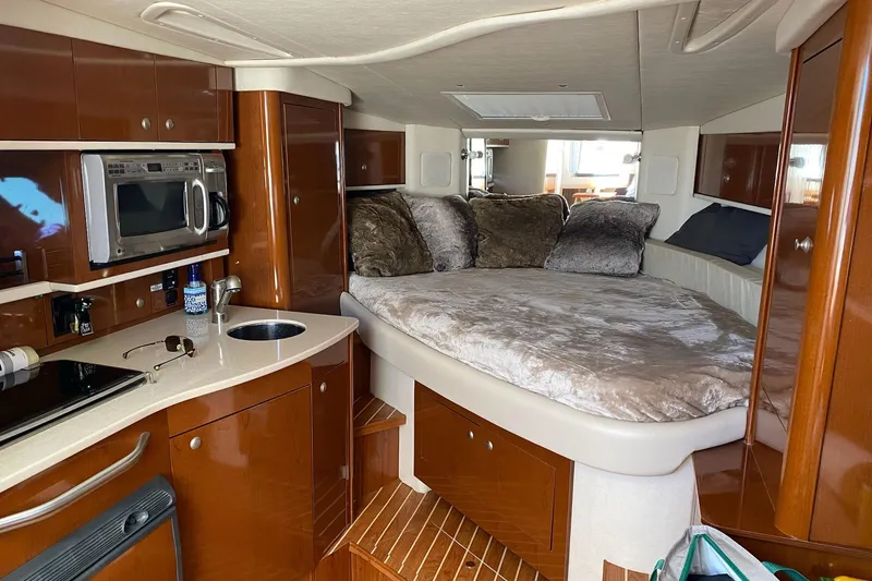 Slide: The Image of Luxurious interior of 2008 Sea Ray 310 Sundancer with cozy bed and modern kitchenette. - 27