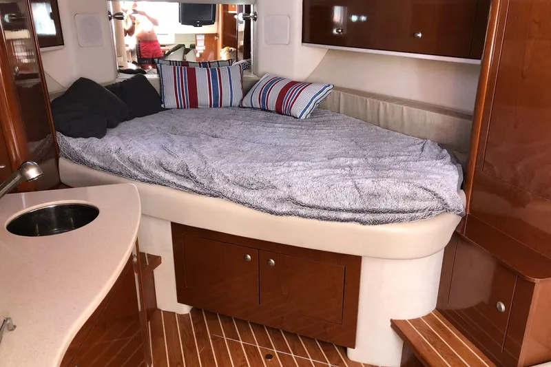 Slide: The Image of Luxurious cabin interior of 2008 Sea Ray 310 Sundancer with cozy bed and wooden finishes. - 28