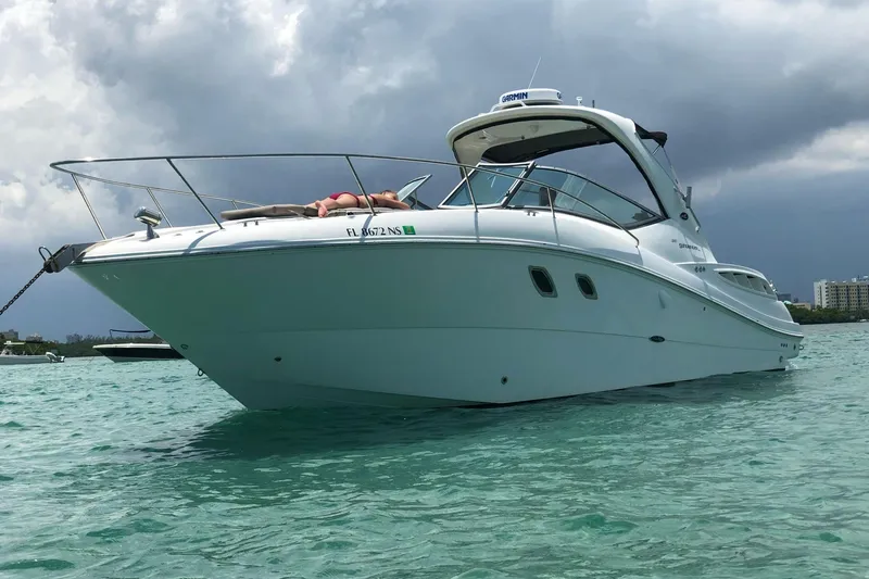 Slide: The Image of 2008 Sea Ray 310 Sundancer yacht anchored in clear turquoise water under cloudy skies. - 3