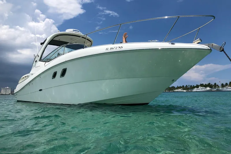 Slide: The Image of 2008 Sea Ray 310 Sundancer boat on clear turquoise water under a partly cloudy sky. - 4