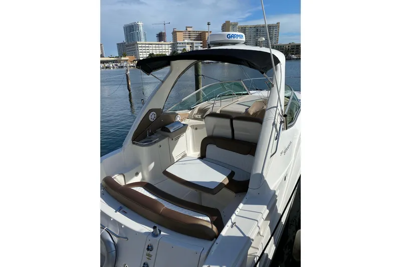 Slide: The Image of 2008 Sea Ray 310 Sundancer boat docked with city skyline in background. - 9