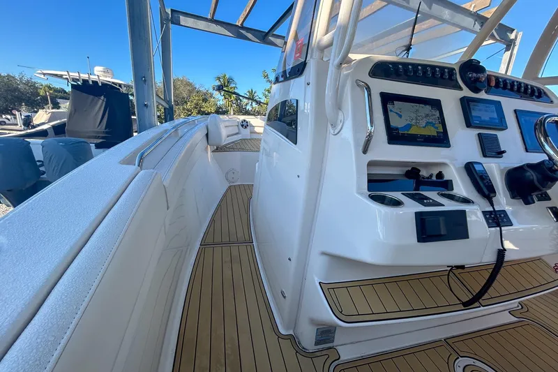 Slide: The Image of 2021 Grady-White Freedom 325 boat interior with navigation controls and teak flooring. - 9