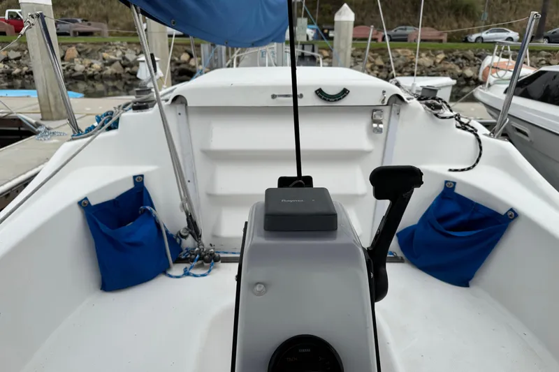 Slide: The Image of 2005 MacGregor 26M Powersailer cockpit with steering controls and blue storage pockets. - 10