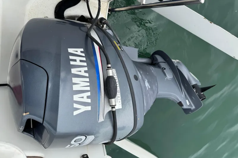 Slide: The Image of Yamaha outboard motor on 2005 MacGregor 26M Powersailer, floating on water. - 13