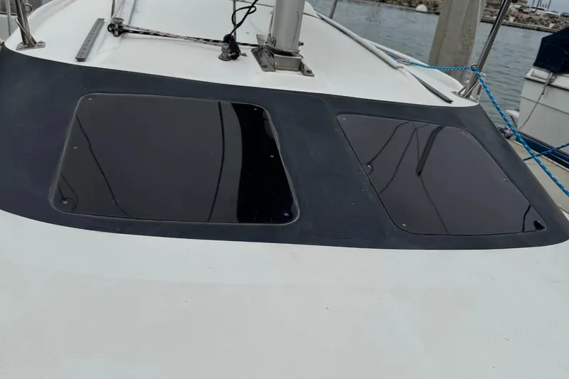 Slide: The Image of 2005 MacGregor 26M Powersailer deck with dual tinted hatches, docked at marina. - 15