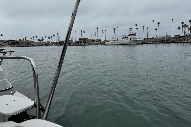 Slide: The Image of Calm marina view with a 2005 MacGregor 26M Powersailer, palm trees in the background. - 16