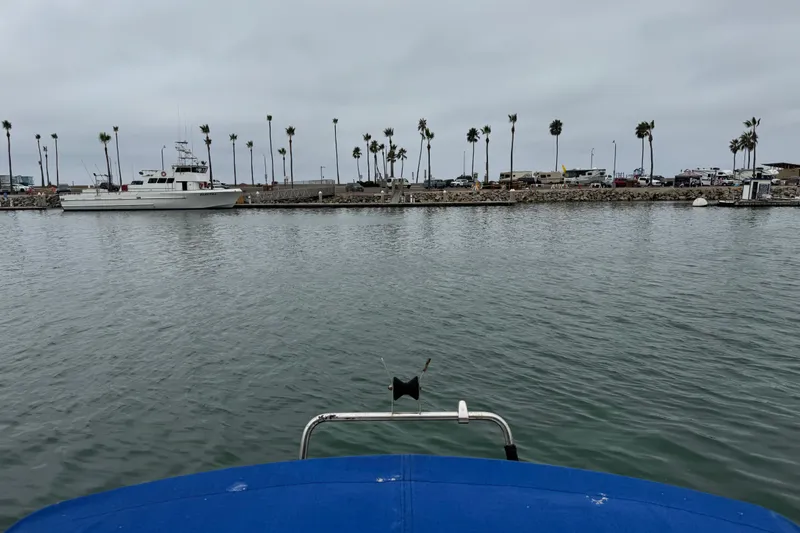 Slide: The Image of View from a 2005 MacGregor 26M Powersailer in a marina with palm trees and boats. - 17