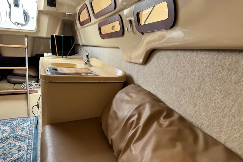 Slide: The Image of Interior of 2005 MacGregor 26M Powersailer with seating, sink, and nautical decor. - 21