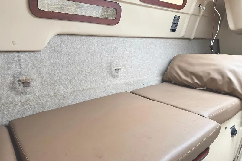 Slide: The Image of Interior cabin of 2005 MacGregor 26M Powersailer with cushioned seating and window. - 26