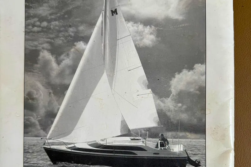 Slide: The Image of 2005 MacGregor 26M Powersailer sailing under dramatic cloudy skies. - 32