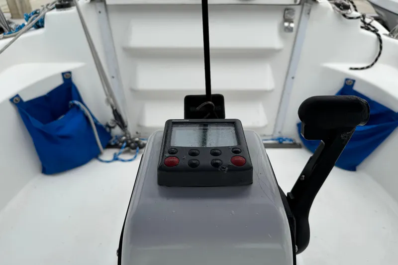Slide: The Image of Cockpit of 2005 MacGregor 26M Powersailer with control panel and blue storage bags. - 9