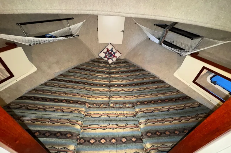 Slide: The Image of Interior of 2004 Camano 31 Troll boat with patterned bedding and storage hammocks. - 12