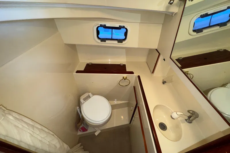 Slide: The Image of Bathroom interior of 2004 Camano 31 Troll boat with sink, toilet, and porthole window. - 15