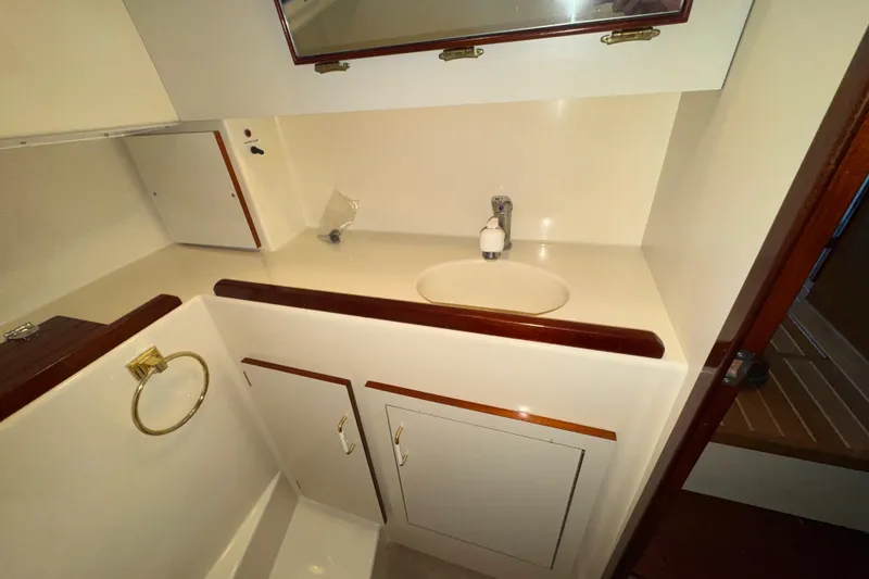 Slide: The Image of 2004 Camano 31 Troll boat bathroom with sink, mirror, and storage cabinets. - 17