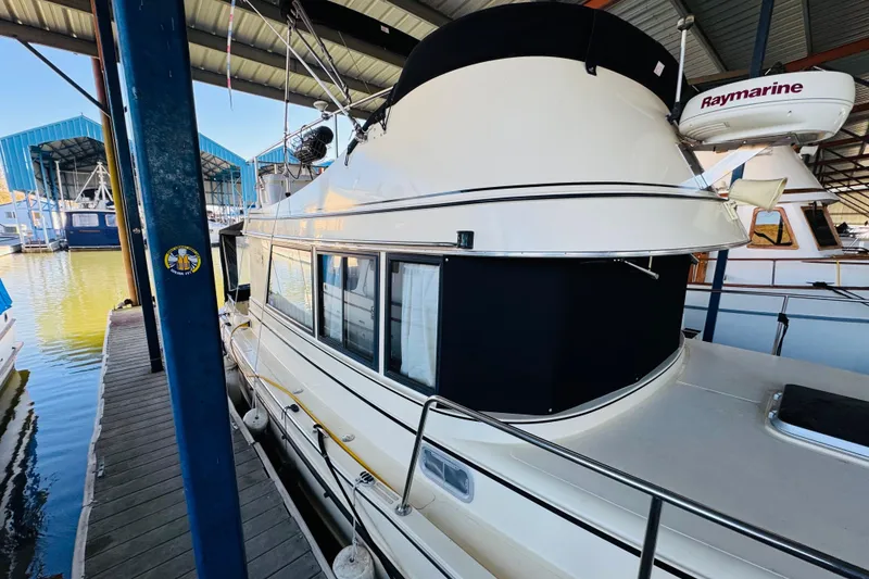 Slide: The Image of 2004 Camano 31 Troll boat docked in a marina under a covered structure. - 19