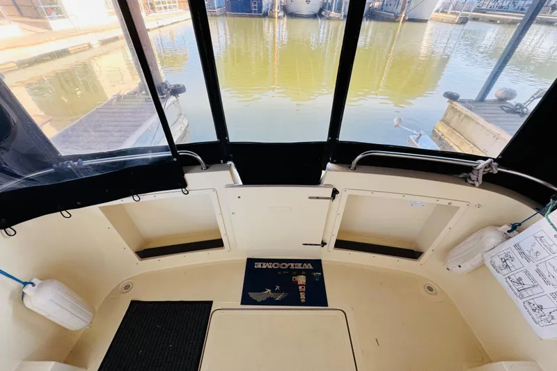 Slide: The Image of 2004 Camano 31 Troll boat interior with dock view, featuring storage compartments and fenders. - 22