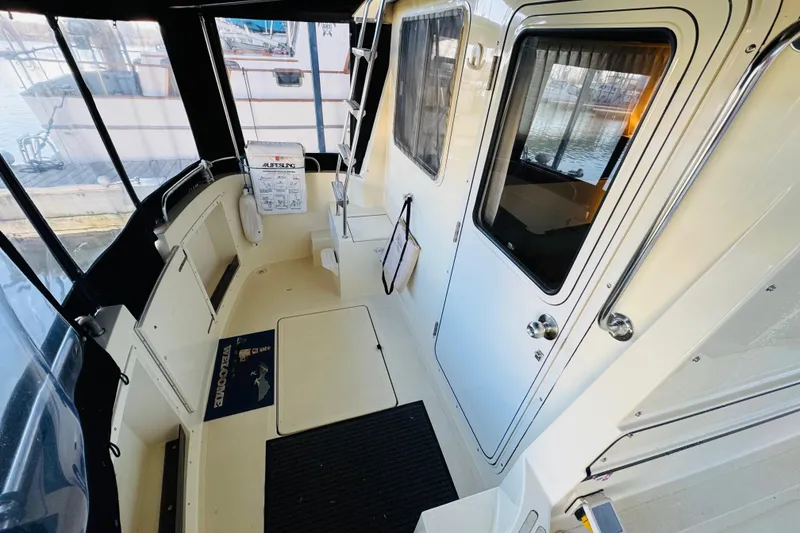 Slide: The Image of 2004 Camano 31 Troll boat interior with seating, door, and dock view. - 24