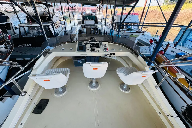 Slide: The Image of 2004 Camano 31 Troll boat interior with helm and three swivel chairs in marina. - 32