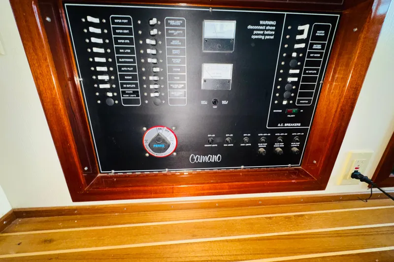 Slide: The Image of Electrical control panel of a 2004 Camano 31 Troll boat, featuring switches and gauges. - 51