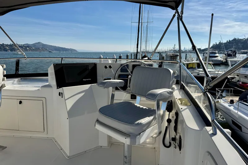 Slide: The Image of 2001 Sabre Sedan Bridge helm with marina view, featuring a captain's chair and navigation equipment. - 12