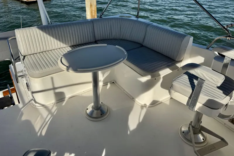 Slide: The Image of 2001 Sabre Sedan Bridge yacht seating area with table and chairs on deck. - 14