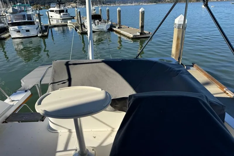 Slide: The Image of 2001 Sabre Sedan Bridge yacht docked at marina, featuring covered seating area. - 17