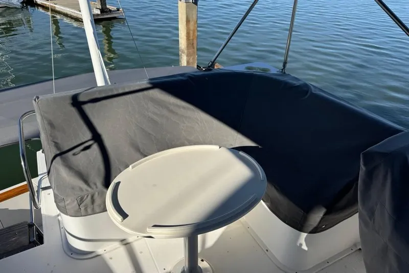 Slide: The Image of 2001 Sabre Sedan Bridge boat deck with covered seating and table by the water. - 20