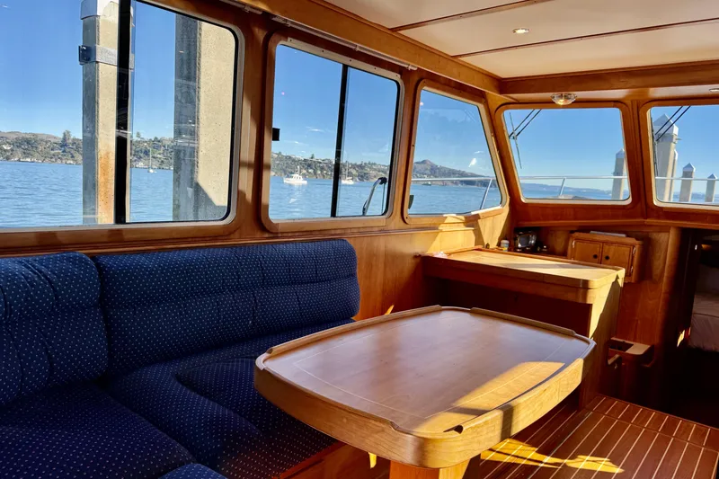 Slide: The Image of Interior of 2001 Sabre Sedan Bridge yacht with wooden table and blue seating. - 24