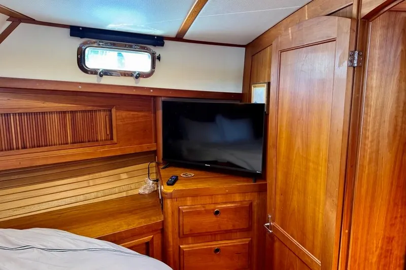 Slide: The Image of Wood-paneled cabin interior of 2001 Sabre Sedan Bridge with TV and porthole window. - 39