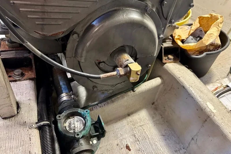 Slide: The Image of Engine compartment of a 2001 Sabre Sedan Bridge boat, showing mechanical components and a pump. - 52