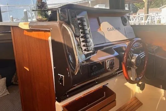 Slide: The Image of 2024 Ranger Tugs R-27 helm with Garmin navigation system and wooden steering wheel. - 15