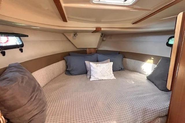 Slide: The Image of 2024 Ranger Tugs R-27 cabin interior with cozy bedding and natural light. - 19